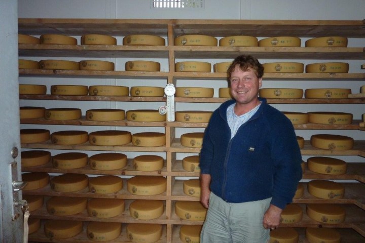 man with a wall full of cheese