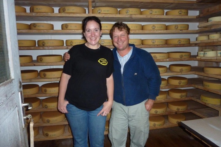 couple in front of a wall full of cheese