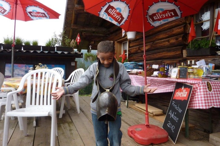 boy with a cow bell on his neck