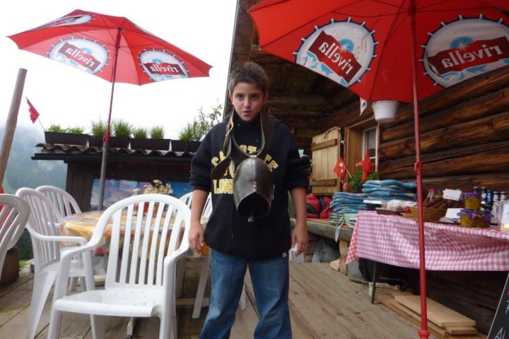 boy with a cow bell around his neck