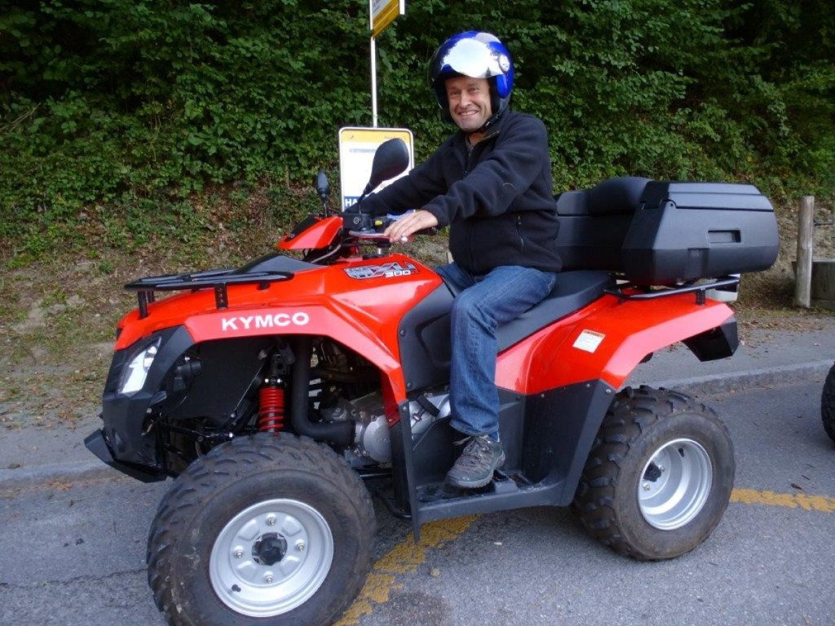 man with a black sweater on a red quad