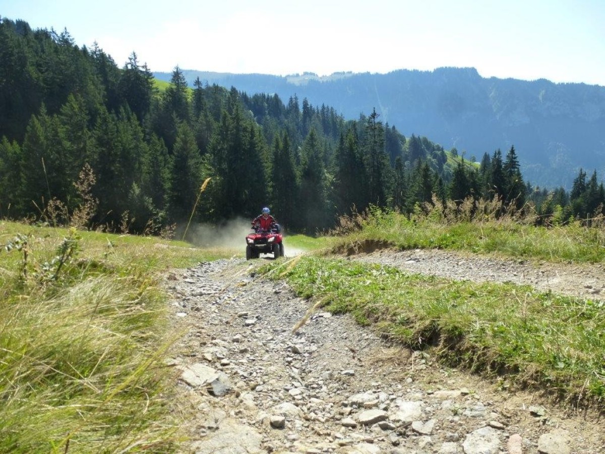 man racing a red quad through a road