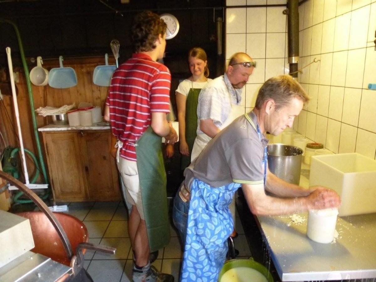 people filling buckets with cheese