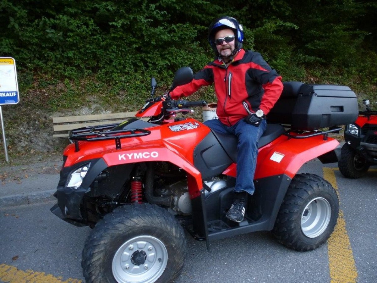 man with a red jacket on a red quad