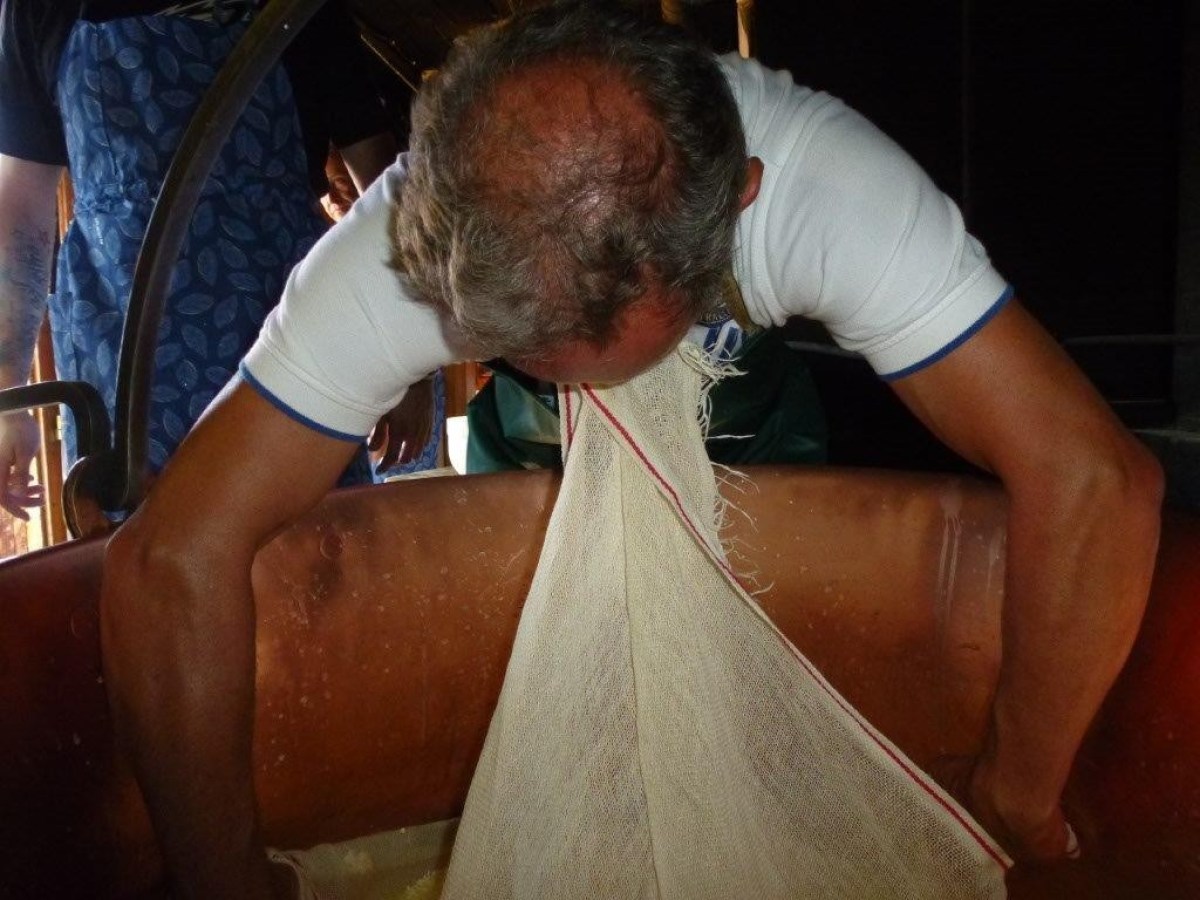 man holding a fabric with the mouth while making cheese