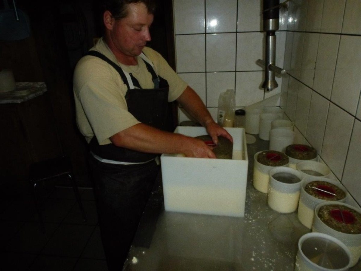 man cooking cheese with a stone