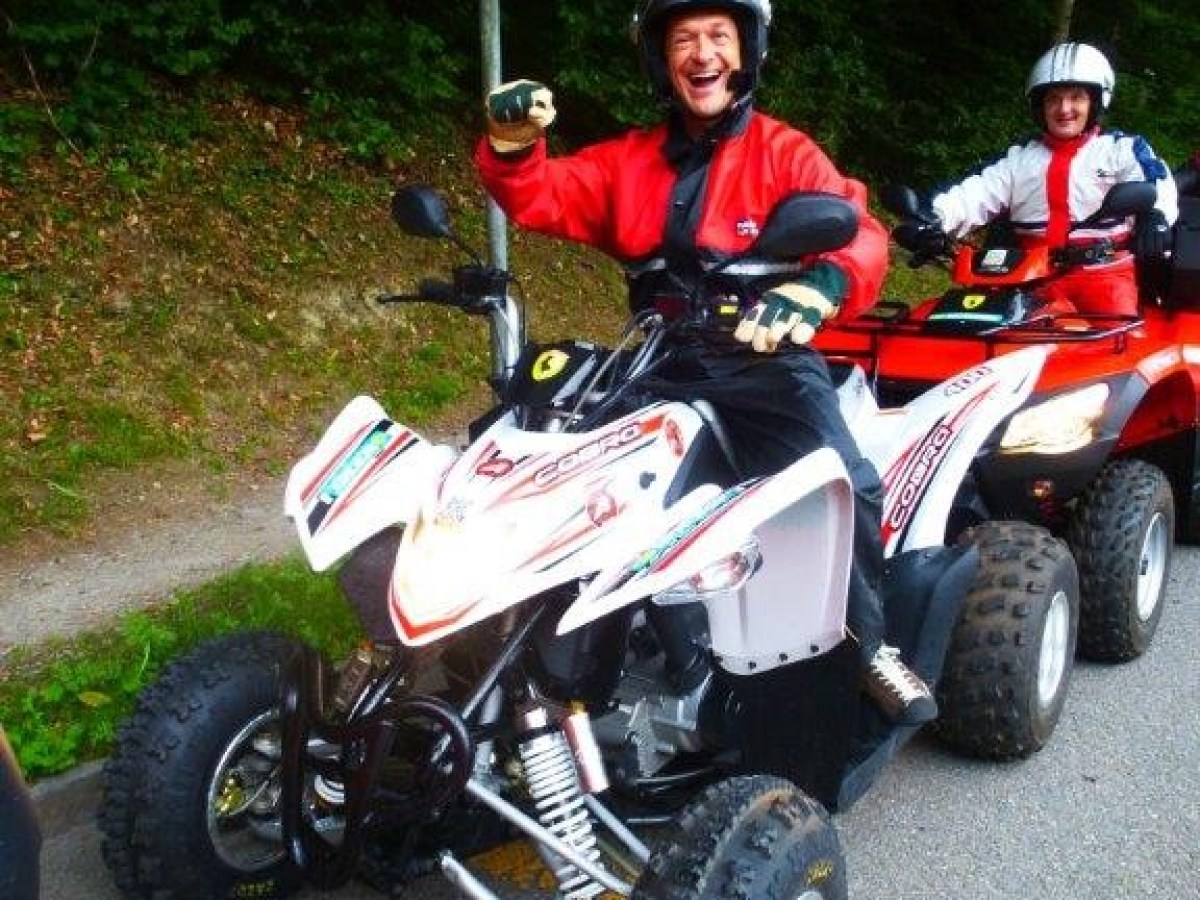 man on a white quad smiling