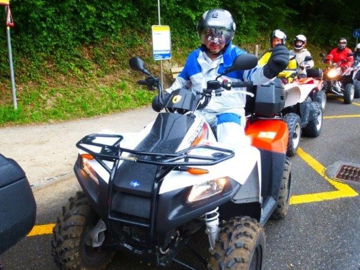 man with a helmet and blue jacket on a quad