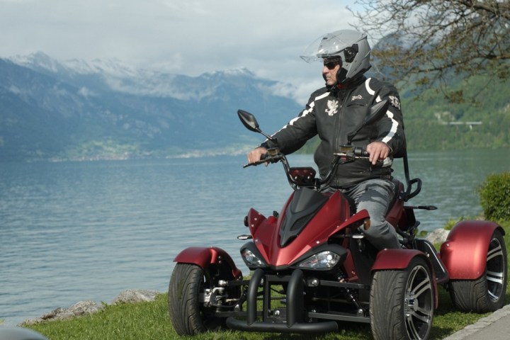 a man riding a motorcycle next to a body of water