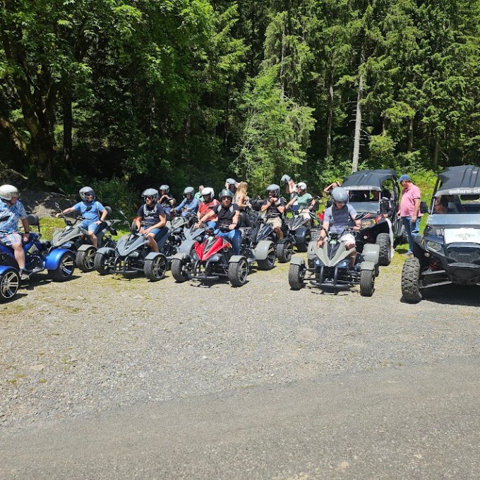 a group of people riding a motorcycle down a dirt road
