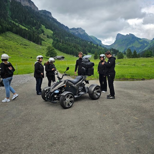 a group of people on a motorcycle parked on the side of a mountain