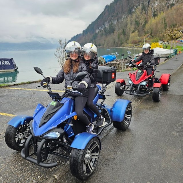 a group of people on a motorcycle in a parking lot